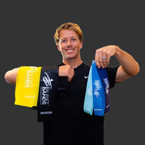 Oseopathy Specialist Tom Allan in a black Nike shirt, holding up all 5 Pro Balance Bands